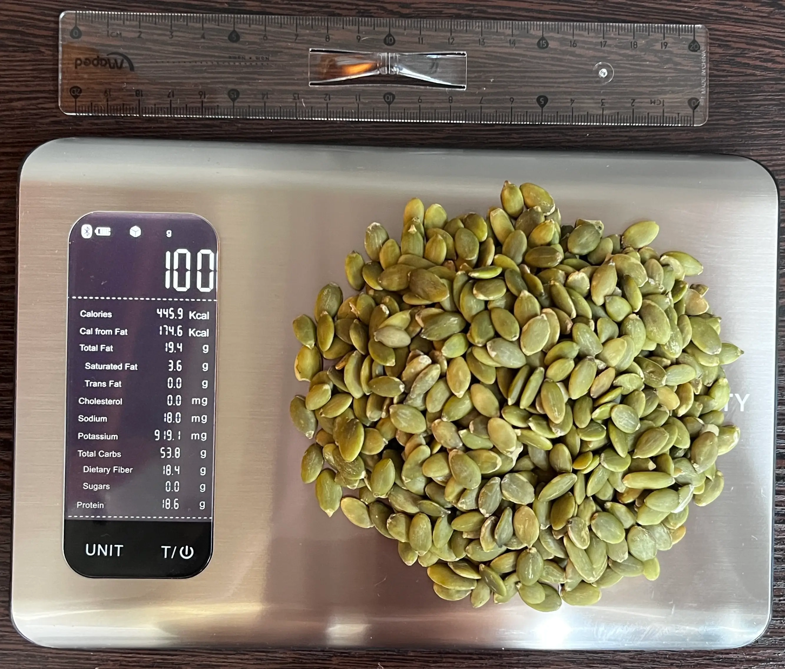446 Calories or 100 Grams of Pumpkin Seeds on scale